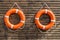 Two orange lifebuoys hanging on a wall