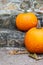 Two orange pumpkins decorating the entryway stairs to a home.