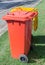 Two orange and yellow color litter bins in garden
