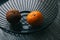 Two oranges in metal basket healthy and rotten one