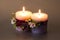 Two ornamental candles with winter fruit tied