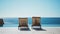 Two outdoor lounge chairs next to sea