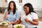 Two Overweight Women On Diet Eating Healthy Meal In Kitchen