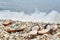 Two pair of slippers on the beach on the cobblestones against the waves by the sea. Toned