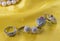 Two pairs of earrings and ring on the yellow