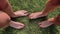 Two pairs of female feet stand opposite each other on the green grass