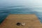 Two pairs of flip-flops on wooden deck near seashore