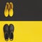 Two pairs of gumboots - yellow female and black male - standing opposite to each other on the inverse backgrounds.