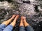 Two pairs of ladies legs immersed in cold running water of a river