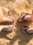 Two pairs of legs male and female with a beautiful pedicure in spanking on the sea in a tropical resort on the sand on the beach a