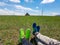 Two pairs of legs with whoes on lying on a vast pasture in Xilinhot in Inner Mongolia. In the back there is a heap of stones