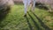 Two pairs of male lovers legs walk on the green grass among lavender in the rays of the setting sun