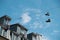 Two pairs of shoes tied at the shoelaces hangs on a wire between houses in Paris, France. Quirky horizontal background.