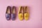 Two pairs of suede moccasins shoes lilac and yellow over pastel pink background