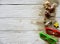 Two pairs of sunglasses, sea shells, yellow wooden star, decorative bottles and sand on a white wooden background.