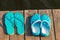 Two pairs of turquoise slates on the edge of a wooden pier, no p