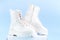 Two pairs of white demi-season boots made of eco-leather with fasteners and laces stand on a white box.