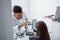 Two panels on the table. Young ophthalmologist is with little female visitor in the clinic