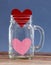 Two paper hearts inside jar