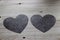 Two paper hearts on a wooden table.