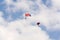 Two parachutists skydiving with colorful parachute clouds blue sky background