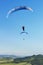 Two Paragliders flying over mountains in summer day