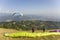 Two paragliders on the hillside before taking off against the backdrop of a mountain valley and flying