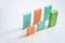 Two parallel rows of blue, orange and green flat wooden bricks making up charts