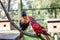 Two parrots are sitting on a branch in the aviary. Rainbow and Red Loris in Kuala Lumpur Bird Park.