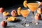 Two peach Bellinis surrounded by peaches, against a dark background.