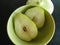 Two pear halves in pale green retro bowl with lid