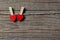 Two pegs with red heart hanging on the rope on wooden backdrop. Happy valentines day