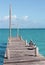 Two pelicans sit on a pier on the Caribbean Sea.