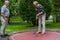 Two pensioners at a minigolf court playing minigolf. He is watch