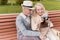 Two pensioners are sitting on the bench and studying a vintage camera. They are going to take a few photos