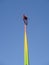 Two people in chairs high in the sky at the peak of the attraction in amusement park