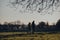 Two people with coffee in hand walking in Broomfield Park, London, UK