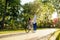 Two people, a couple, are in the city park on a sunny day, a woman is sitting on a bicycle, a man is holding her and talking to