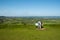 Two people discuss the view by the information signboard at Coaley Peak viewpoint