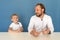 Two people, father and son, a man and a child with microphones on white T-shirts are discussing something, filming a children`s