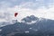 Two people flying with a Tandem and enjoying the freedom, high up in the sky with a few clouds and mountains covered in snow in