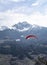 Two people flying with a Tandem and enjoying the freedom, high up in the sky with a few clouds and mountains covered in snow in