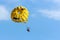Two people are gliding using a parachute on the background of the blue sky. Summer background