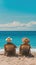 Two people in hats on sun loungers facing the ocean under a clear blue sky, serene beach setting