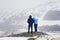 Two people, a man and a woman admire the winter landscape of the Norwegian mountains and make a photo on the phone.