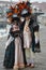 Two people masked during the carnival in Venice pose for the photo near a canal