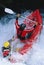 Two people paddling inflatable boat down rapids