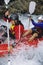 Two people paddling inflatable boat down rapids