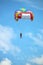 Two people parasailing with parachute on blue sky