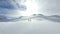 Two people pilot and photographer standing on summit of snowy mountain peak